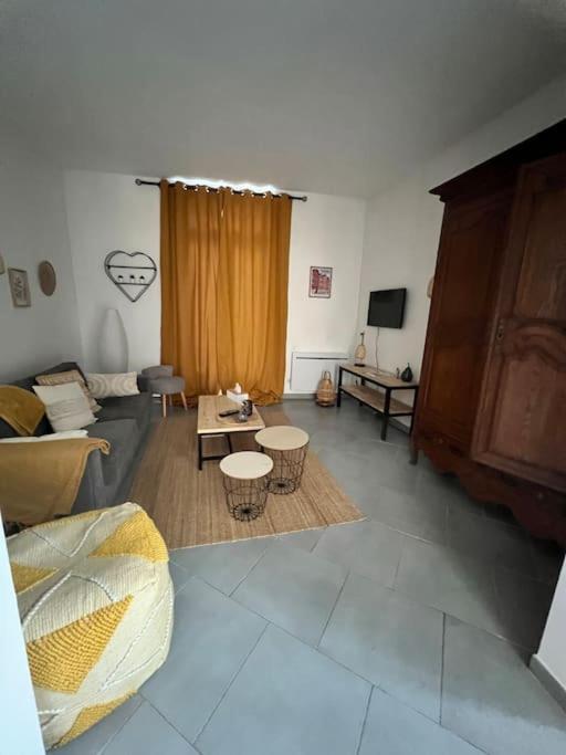 un salon avec un canapé et une table dans l'établissement La jolie petite maison, à Saint-André-les-Vergers