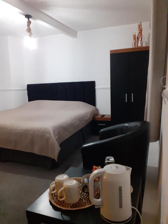 a room with a bed and a table with a tea kettle at Inspiro house4 in Scarborough