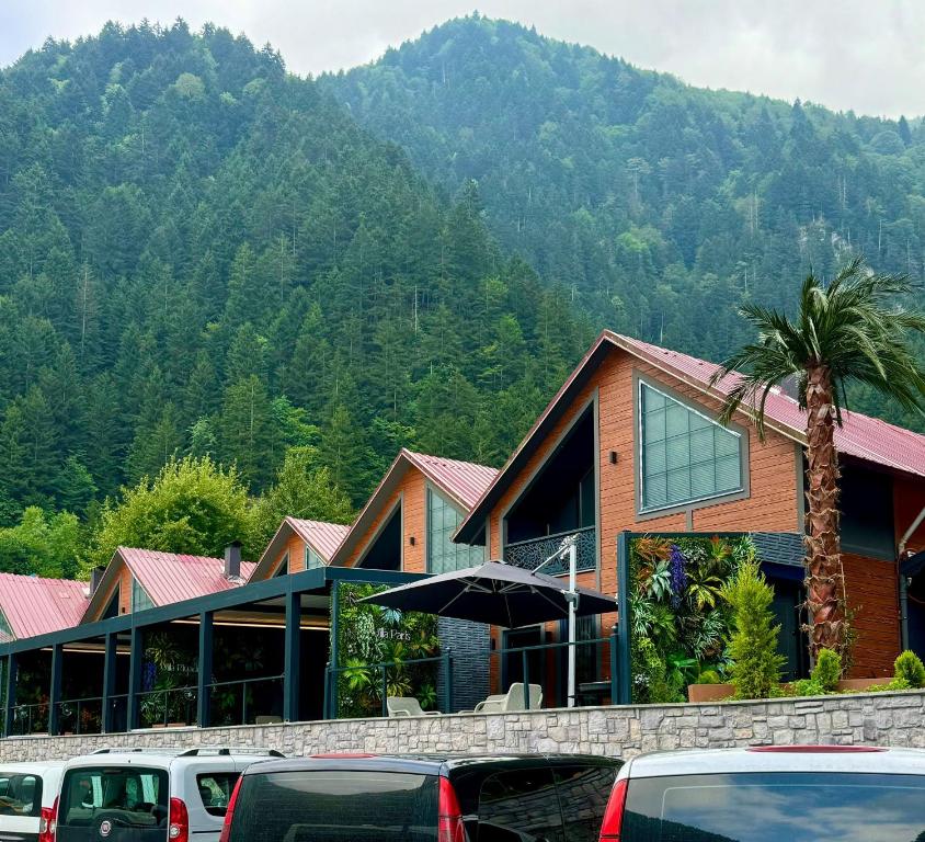 a building with cars parked in a parking lot at Uzungol Ada Bungalow in Uzungöl
