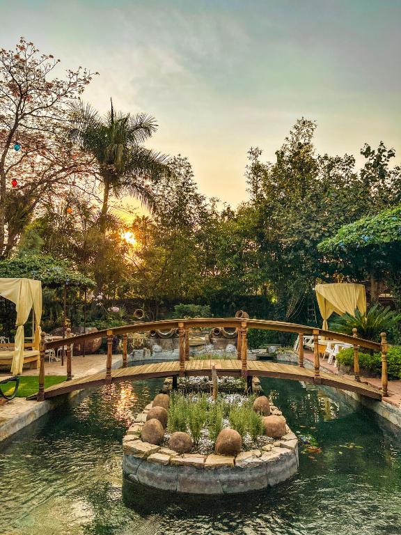 a bridge over a pond in a garden at Finca las Isabeles in Xochitepec