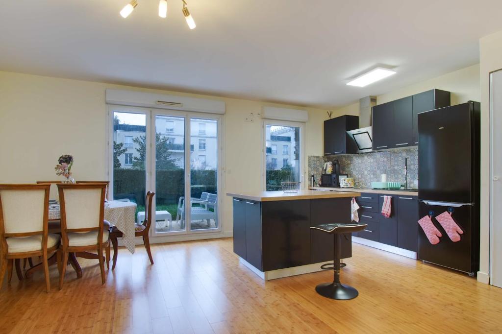 a kitchen and dining room with a table and chairs at Cute garden apartment - Disneyland Paris in Montévrain