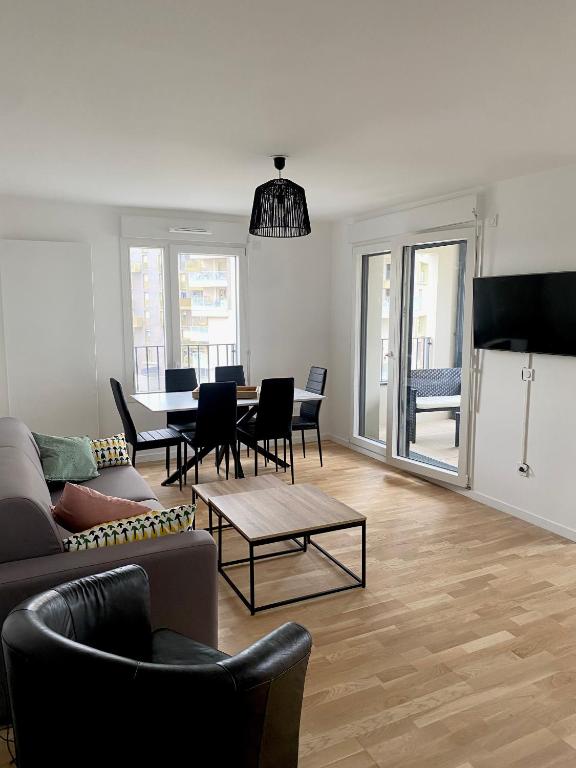 Una sala de estar con un sofá y sillas y una mesa. en 3 pièces tout neuf de haut standing à 10mn de Paris avec terrasse vue Sacré Coeur, en Asnières-sur-Seine