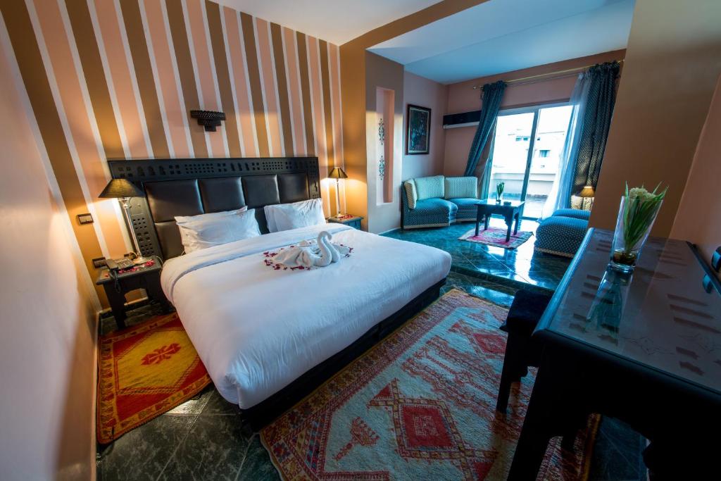 メクネスにあるホテル アクアスのベッドとリビングルームが備わるホテルルームです。