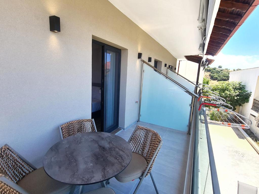 une table et des chaises sur le balcon d'un bâtiment dans l'établissement Agnanti-apartments, à Nikiti