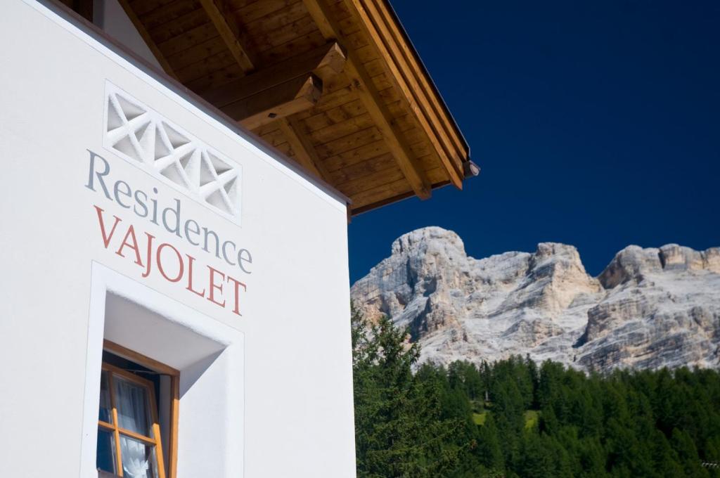 a white building with a mountain in the background at Residence Vajolet San Cassiano in San Cassiano