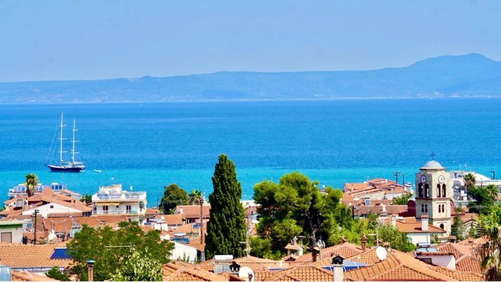 a view of a town with a boat in the water at Sun Sight - Deluxe Infinity View Suites in Pefkochori