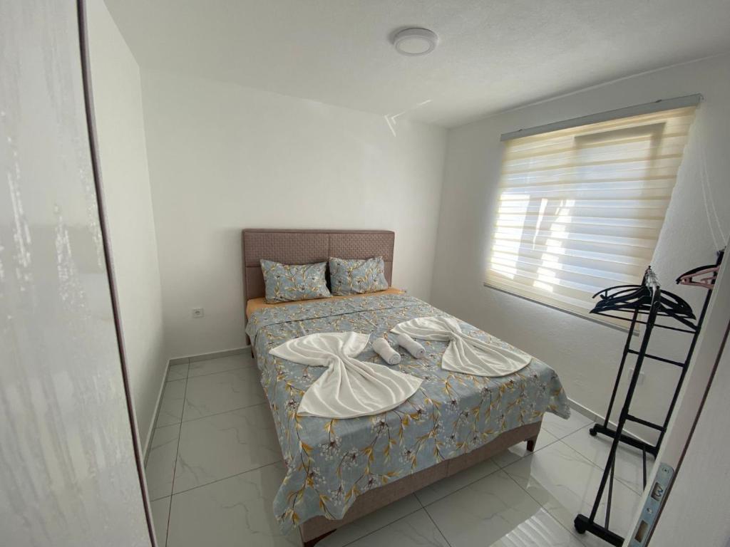 a bedroom with a bed with two towels on it at Apartmani AMAN in Dobra Voda