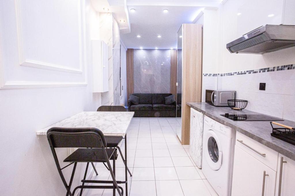 een keuken met een tafel en stoelen in een kamer bij Appartement Royal carré d'or de Paris 17 eme in Parijs