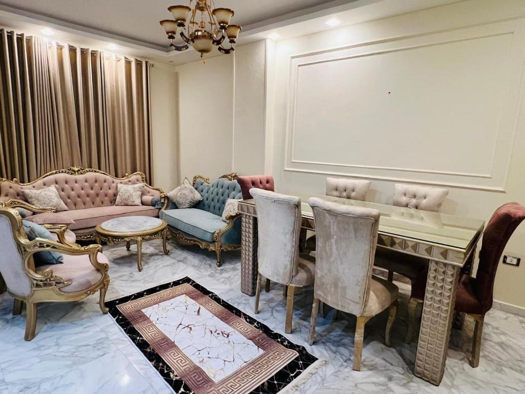 a living room with a table and chairs at شقة فندقية vip برج رئيسي شارع الغشام مع موقف المنصورة in Manshīyat as Sādāt
