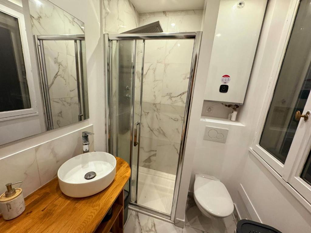 une salle de bain avec une douche, un lavabo et des toilettes dans l'établissement Le sublime SM, à Paris