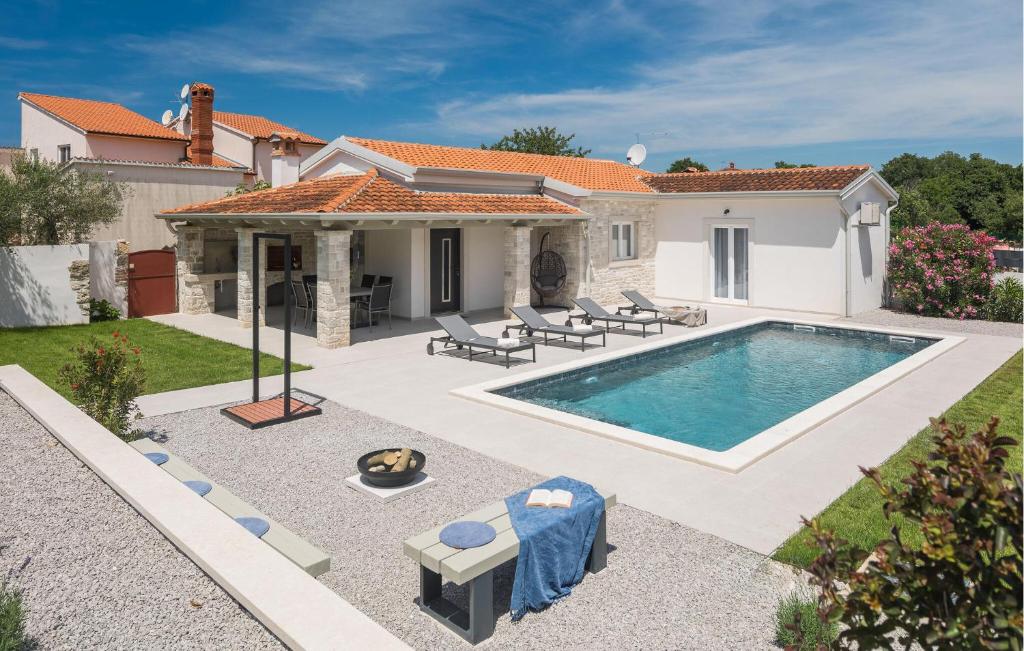 a backyard with a swimming pool and a house at Awesome Home In Sveti Lovrec Pazenati in Sveti Lovreč Pazenatički