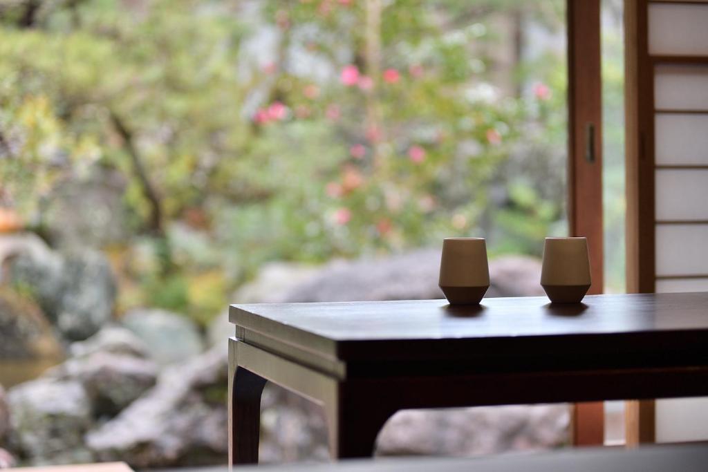 two candles sitting on a table in front of a window at Oni no Sumika in Izu