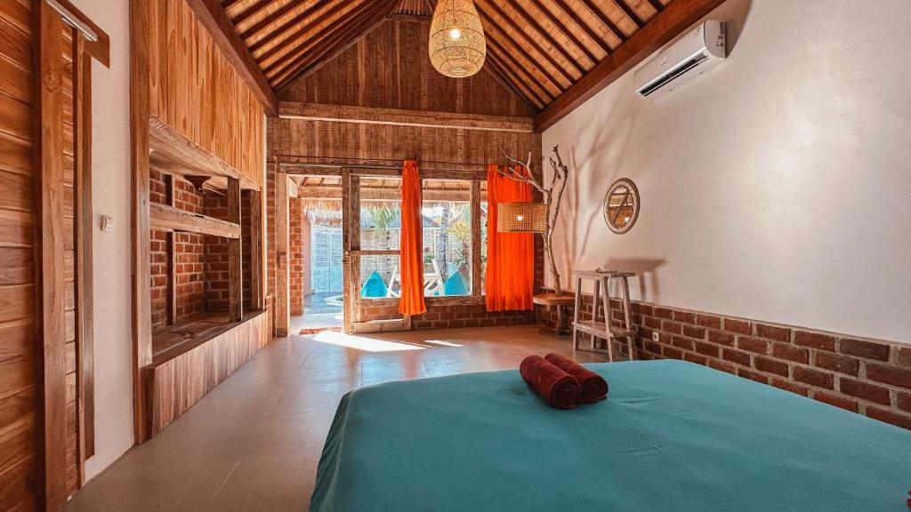 a bedroom with a blue bed in a room with windows at Coconut Dream Villas in Gili Trawangan