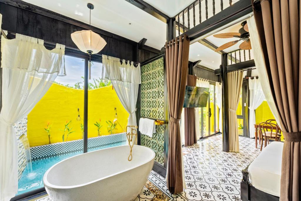 une salle de bain avec baignoire et une grande fenêtre dans l'établissement Rosie Countryside villa- 1BR retreat, à Hiếu Nhơn