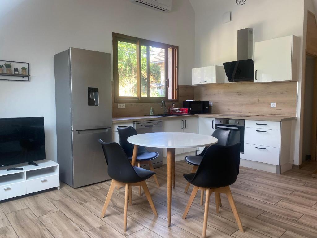 une cuisine avec une table et des chaises et une télévision dans l'établissement Appartement à la campagne, à La Motte-Servolex