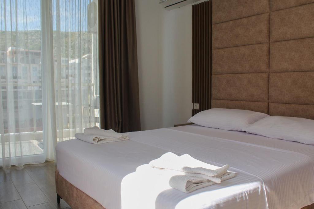 Uma cama ou camas num quarto em Hotel SUNSET Shengjin