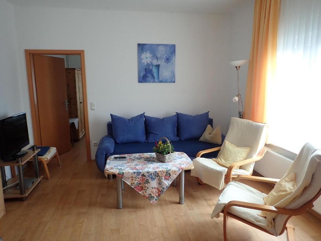 a living room with a blue couch and a table at Gemütliche Ferienwohnung in der Lüneburger Heide in Sprakensehl
