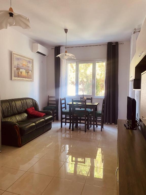 a living room with a couch and a table at Appartamento Valamar Nikolla 2 camere in Hamallë