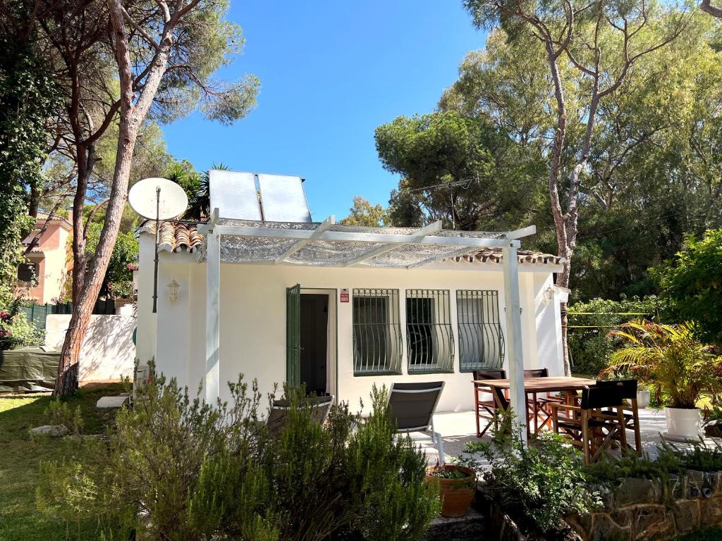 a small white house with a table and chairs at Elviria Beachside House Marbella in Marbella