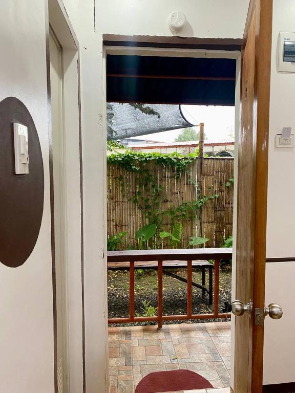 a door to a balcony with a view of a garden at Moalboal Panagsama beach TopBudz Hostel in Moalboal