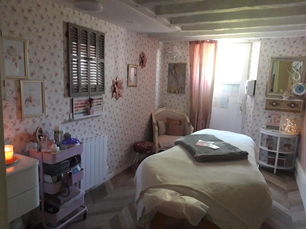 a bedroom with a bed and a chair in it at Chambre Parenthèse Cosy et institut in Neufmarché