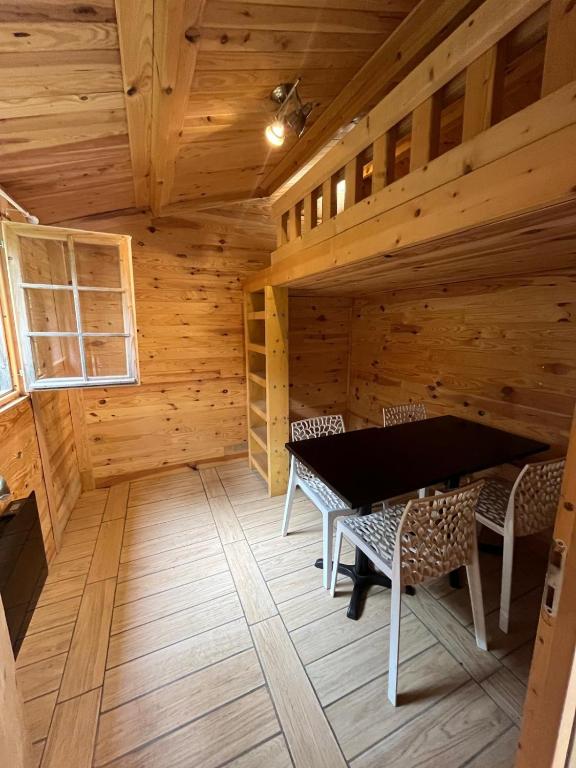 - une salle à manger dans une cabane en rondins avec une table et des chaises dans l'établissement Chalet 2 chambres, à Coullons
