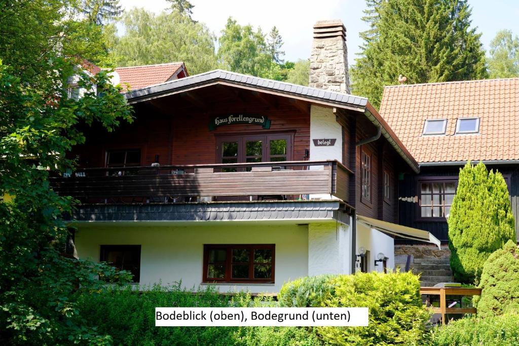 a wooden house with a balcony on the side of it at Ferienwohnungen Forellengrund Schierke in Schierke