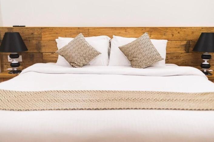 a white bed with four pillows and two lamps at Suffix Retreat - Stay, Dive & Explore Fuvahmulah in Fuvahmulah