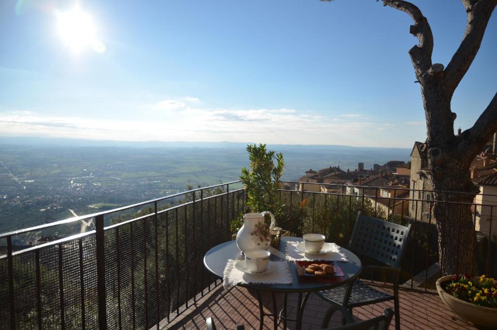 a table and chairs on a balcony with a view at Donnaberarda in Cortona