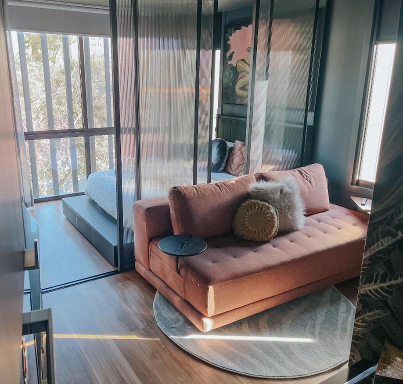 a couch with a teddy bear on it in a living room at Green Rooms Braddon - Themed Micro Apartments in Canberra's Trendiest Neighborhood in Braddon