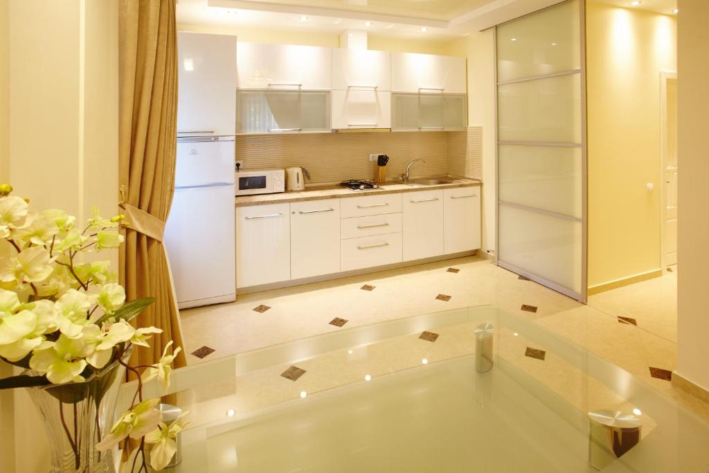 a kitchen with white cabinets and a white refrigerator at Central Park Apartments in Chişinău