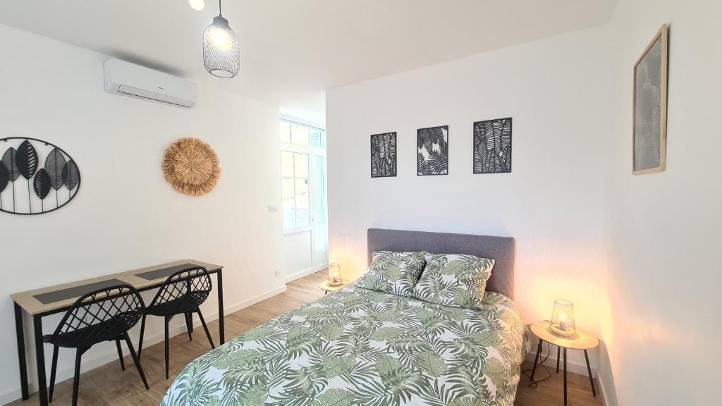 une chambre avec un lit, une table et des chaises dans l'établissement Studio Ludo 1, parking privé, wifi, climatisation, entrée autonome, à Poitiers