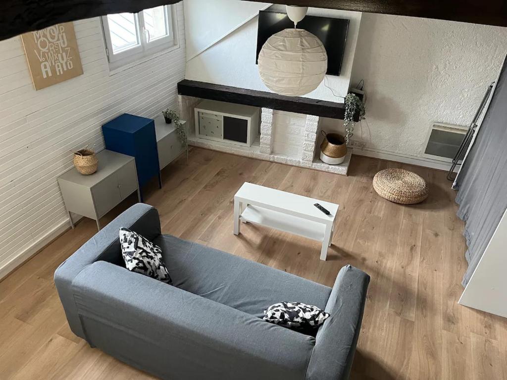 un salon avec un canapé bleu et une table dans l'établissement Charmant T3 cœur de ville, à Orléans