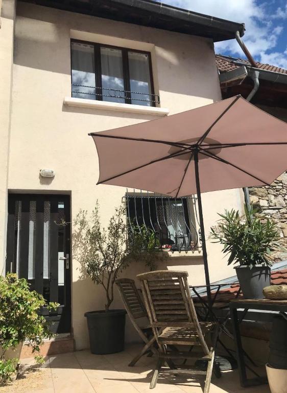 un parasol rose, deux chaises et une table dans l'établissement Au près de tout, à Neuvecelle