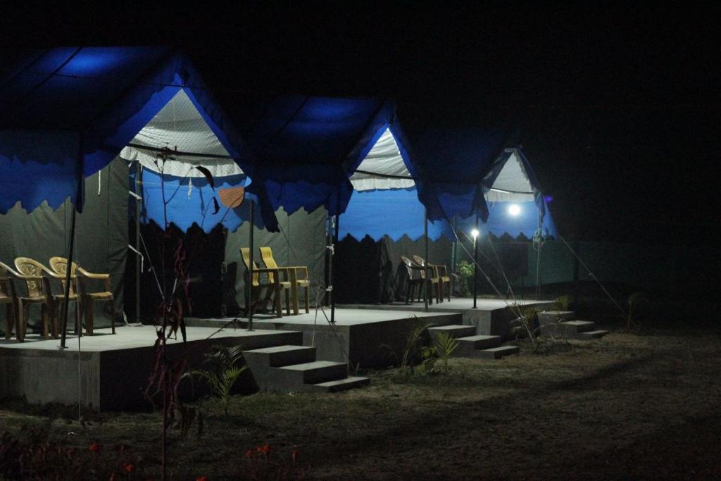 a tent with chairs and tables in the dark at Bhitarkanika Eco Resort TENT in Righāgarh