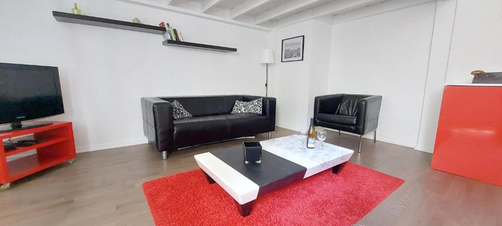 un salon avec un canapé, une table et une télévision dans l'établissement Appartement centre ville, à Nantes