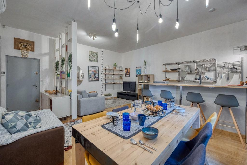 un salon avec une table et une cuisine dans l'établissement Le Chaleureux - Verdun - Centre Ville, à Grenoble