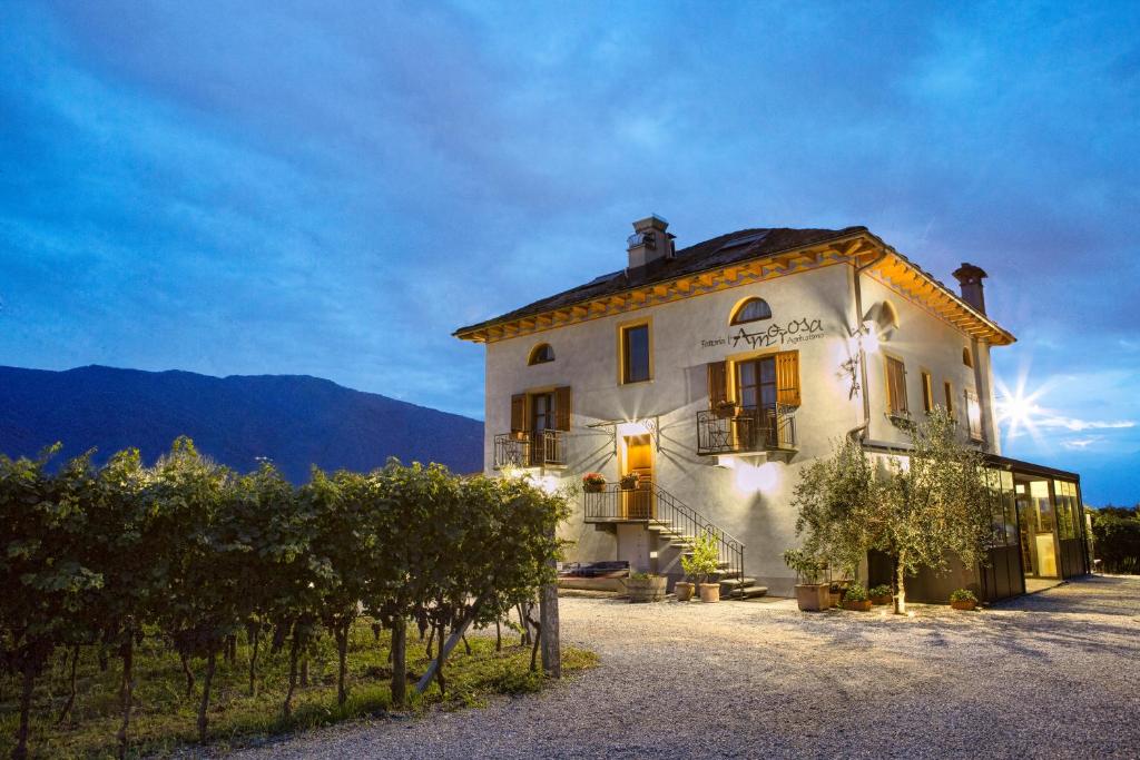 a large white building with trees in front of it at Fattoria l'Amorosa in Sementina