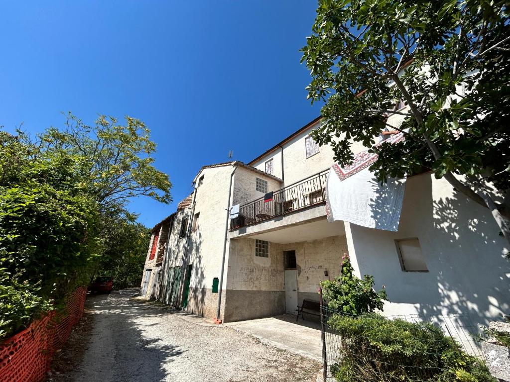 a white building with a balcony on the side of it at La quiete tra le montagne in Apiro