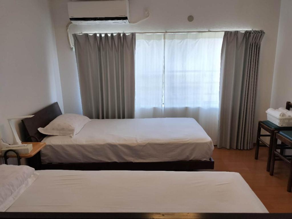 大阪Guesthouse Atelier Ten 民泊アトリエ天的有两张床和一扇窗户的酒店房间