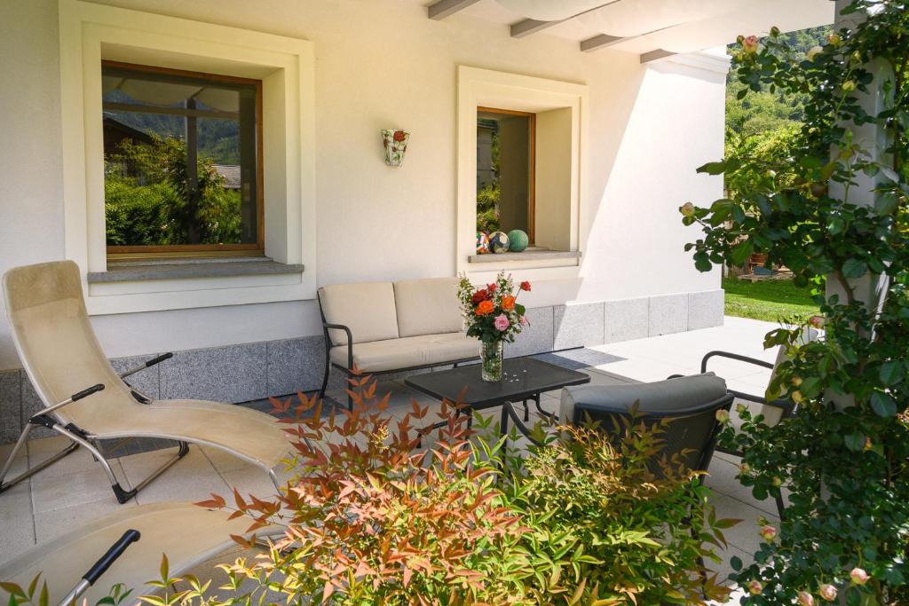 a patio with a couch and a table and chairs at Suite Santa Maria in Lovero Valtellino
