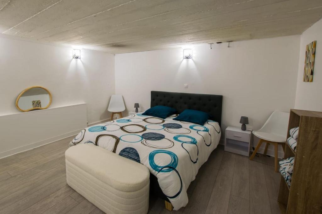une chambre avec un grand lit et une chaise dans l'établissement SPA hyper centre jardin, à Boulogne-sur-Mer