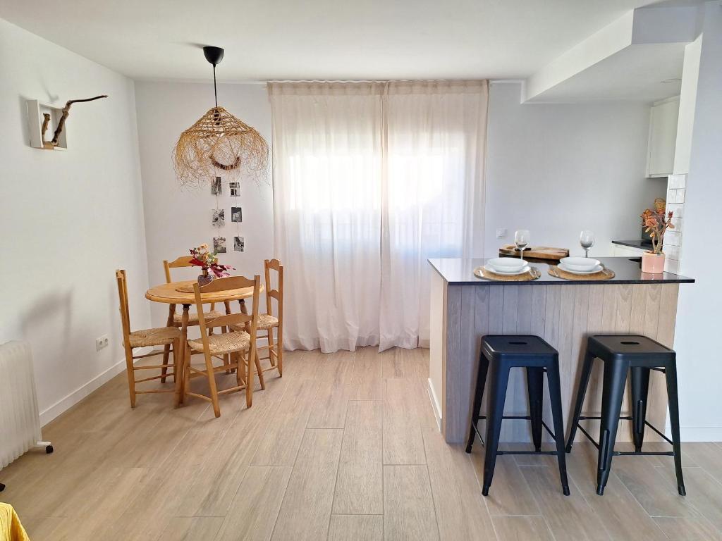 a kitchen and dining room with a table and stools at Casa rural El Rincón de la Yedra in Setenil