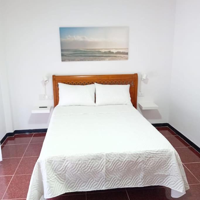 a bedroom with a white bed with two pillows at APAR MARI 2c in Las Lagunas