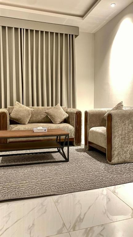 a living room with a couch and a coffee table at قصر أباهي للوحدات السكنية المفروشة in Al Kharj