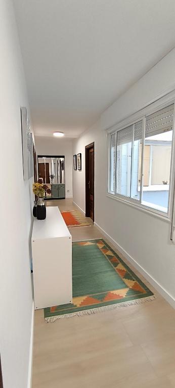 a living room with a white refrigerator and a window at O fogar de Sara in O Grove