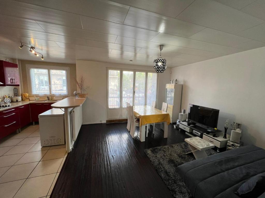 une cuisine et un salon avec un canapé et une table dans l'établissement Bel appartement familial 6 personnes avec balcon, à Noisy-le-Sec