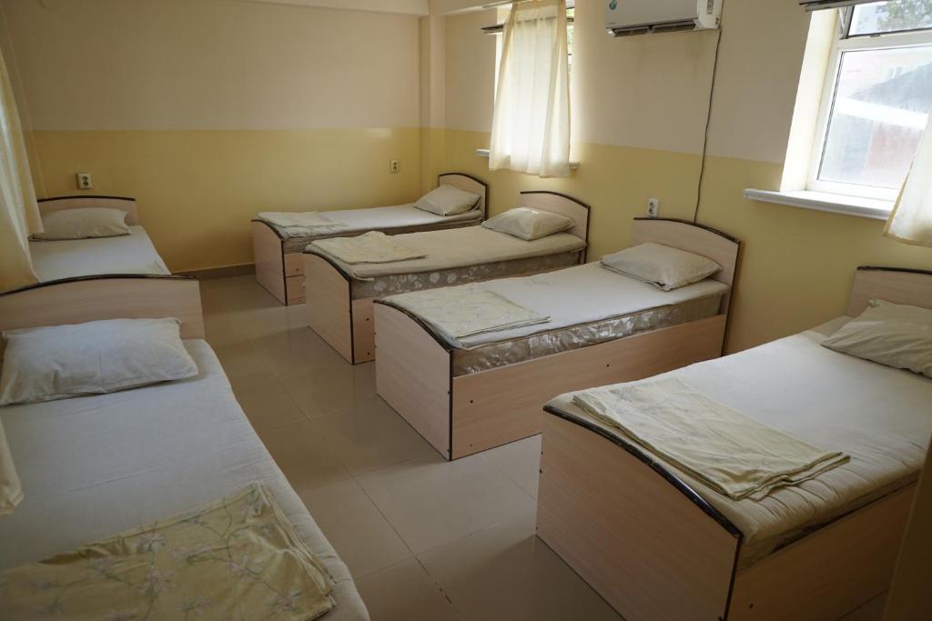 a room with four beds and a window at Sakura Guesthouse in Bishkek