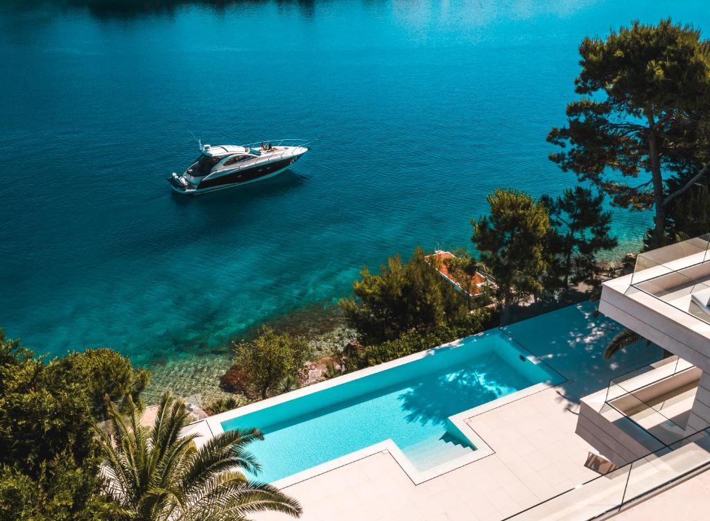 a boat in the water next to a swimming pool at Villa Mila in Selca