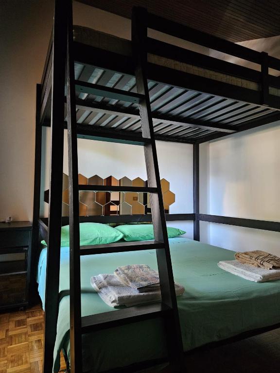 sypialnia z 2 łóżkami piętrowymi i zieloną pościelą w obiekcie Villa a schiera raffinata con giardino w Lignano Sabbiadoro